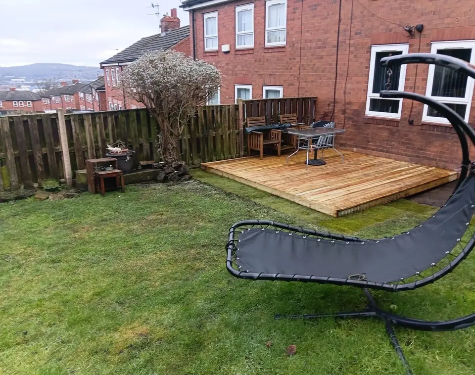 Finished timber deck beside a lawn and brick house